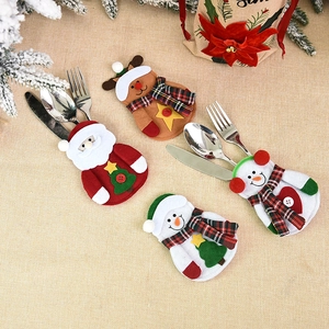 Christmas silverware holders featuring Santa, snowman, and reindeer on a rustic linen background