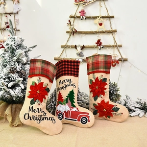 Three decorative Christmas stockings with gnome truck designs and red plaid cuffs