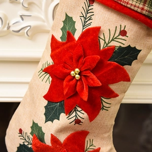 Christmas stocking with red velvet poinsettia flower and embroidery on beige burlap fabric
