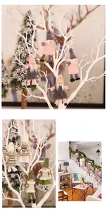 Close-up of knitted faceless gnome ornaments hanging on white Christmas tree branches