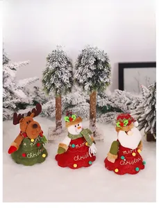 Detailed view of three plush Christmas dolls with Merry Christmas embroidery