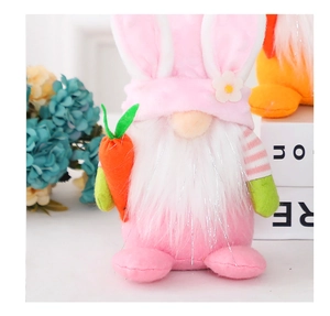 Detail of pink Easter gnome plush with long rabbit ears holding an orange carrot prop
