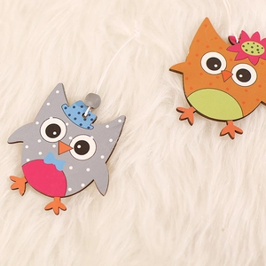 Set of two cute wooden owl hanging ornaments with colorful hats and flowers for Easter decor
