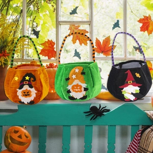 Three Halloween velvet candy bags with gnome designs and pumpkin accents on an autumn ledge