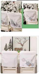 Detail of white plush Christmas chair covers with embroidered snowflake and forest patterns