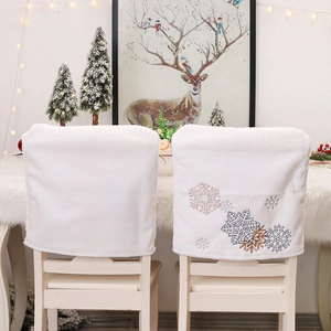 White plush Christmas chair covers with embroidered snowflakes for holiday home decor