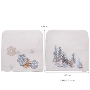 Pair of white plush Christmas chair covers with embroidered snowflake and pine tree patterns