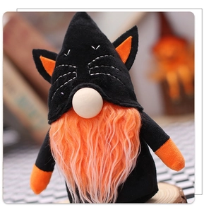 Detail of Halloween gnome plush with black cat ear hat and orange beard on wood