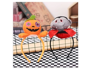 Close-up of Halloween plush headbands with pumpkin and vampire designs on a prop stand