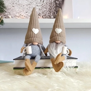 Duo Weihnachts-Wichtel aus Plüsch mit Strickmützen und Tassen auf Buchstapel