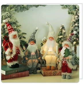 Detail of four lit Christmas gnomes with lanterns and gift boxes for holiday tabletop decor
