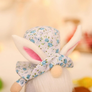 Gnomo di Pasqua in peluche con orecchie da coniglio floreali e barba bianca su sfondo giallo