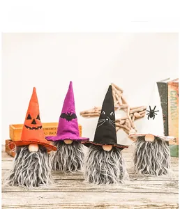 Detail of four festive Halloween gnomes with patterned hats on a rustic wooden desk