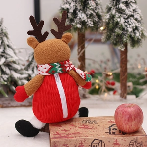 Weihnachts-Rentier-Plüschtier mit roter Strickweste und Schal vor festlichem Hintergrund