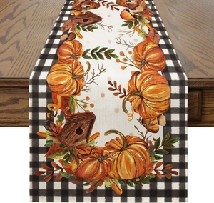 Detailed texture of autumn harvest table runner with pumpkin, fall leaves and buffalo check