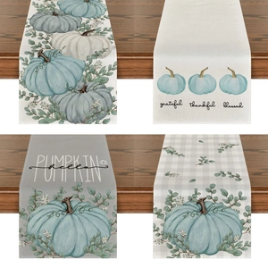 Detail of linen table runner with pumpkins, eucalyptus, and harvest festival typography