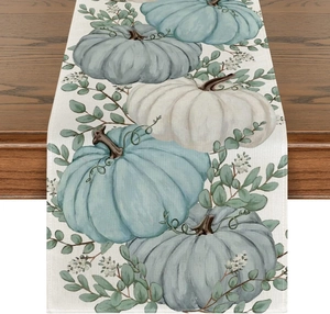 Detailed linen texture of harvest table runner with pumpkins on dark wood table