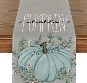 Detail of linen table runner with teal pumpkin, eucalyptus leaves and hello PUMPKIN text