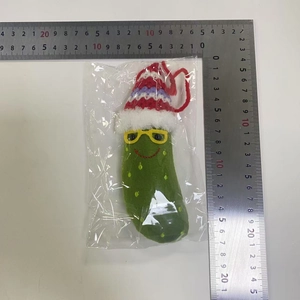 Macro view of Christmas pickle plush ornament with knit hat and glasses including dimensions