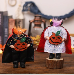 Detail of sequined Halloween vampire dolls with red capes and pumpkin motifs
