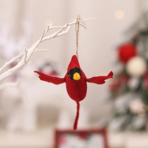 Handcrafted red cardinal bird felt ornament hanging on a white branch for Christmas