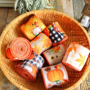 Autumn harvest burlap ribbons with pumpkin and maple leaf patterns in a woven basket