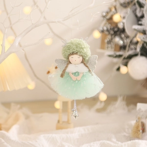Cute green Christmas angel ornament with sequin skirt and silver wings hanging on a branch