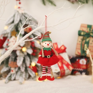 Christmas elf plush girl ornament with red dress and striped hat on festive background