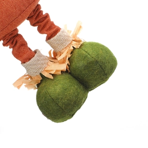Detail of harvest scarecrow plush legs with green felt shoes and orange fabric texture