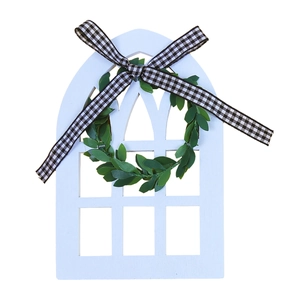 Détail de cadre de fenêtre en bois blanc avec couronne verte et nœud à carreaux