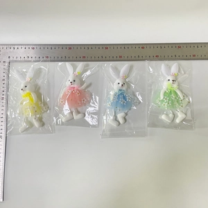 Detailed view of four colorful Easter bunny plush pendants with floral tulle skirts and ruler