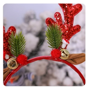 Détail macro du serre-tête de Noël avec bois rouges pailletés, épines de pin et cloches