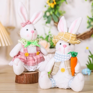 Detail of Easter bunny plush pair wearing pink and yellow plaid outfits on a rustic log