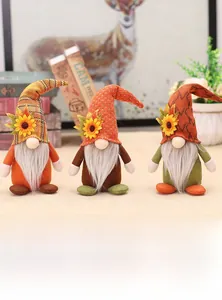 Détail de trois gnomes d'automne avec tournesols et chapeaux tricotés pour la récolte