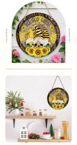 Detail of round wooden Bee Our Guest sign with gnomes and sunflowers in home decor