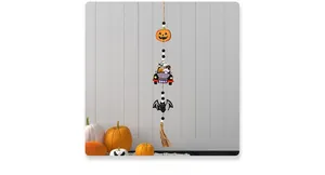 Detail of Halloween wooden pumpkin and ghost beads with a brown tassel hanging on wall
