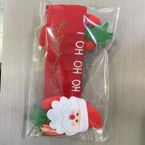 Close-up of red felt Christmas handle cover with Santa Claus and green trees embroidery