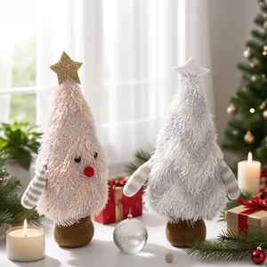 Close-up of cute plush Christmas tree dolls with stars and soft woven arms on a cozy table