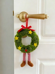 Detail of creative Christmas plush wreath with elf legs hanging on a white wooden door