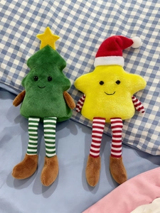 Detail of Christmas plush star and tree dolls with long striped legs on checkered background