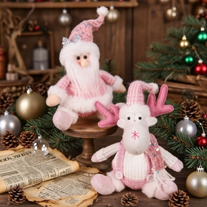 Pink Santa Claus and Reindeer plush dolls on wood background for Christmas decoration
