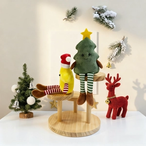 Christmas plush tree and star dolls with striped legs on a wooden shelf display
