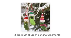 Detailed close-up of three green crochet banana charms with tiny knit hats and accessories