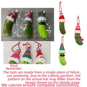 Detail showing plush Christmas pickle ornament with festive hat and red hanging rope