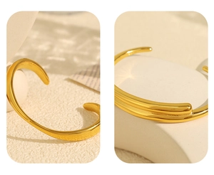 Detailed macro view of an 18k gold-plated open bangle with minimalist asymmetric design