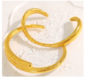 Detail of 18k gold plated nail bracelet and hammered cuff with water droplets