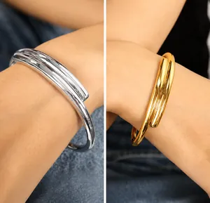 Detail showing gold and silver chunky wrap bracelets on wrist for trendy styling