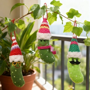 Three-piece set of green felt Christmas pickle ornaments with hats and funny accessories
