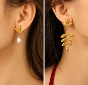 Detail of vintage gold leaf earrings with pearl accents and layered leaf dangle design