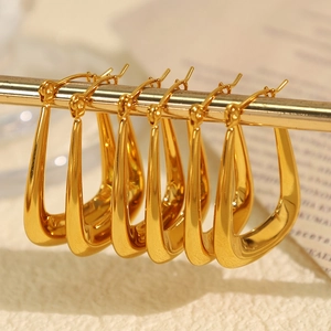 Polished hollow U-shaped thick gold hoop earrings for women on a jewelry display stand